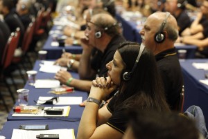 Distribuidores utilizam equipamentos para tradução simultânea de palestra – Foto: Luciano Coca Fotografia.